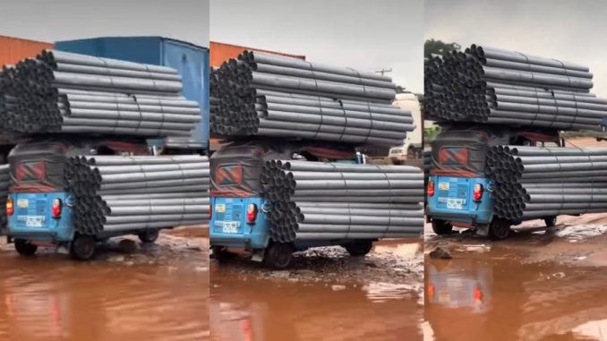 Keke rider struggles on damaged road after overloading his tricycle with aluminum rods (VIDEO)