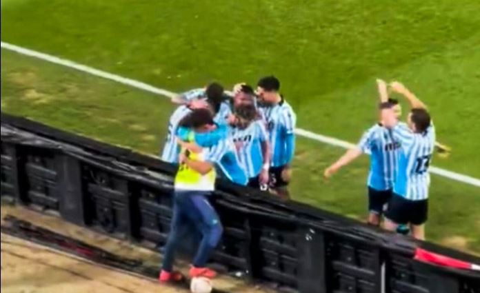 Racing players turned to celebrate with the youngster by hugging him over the advertising boards