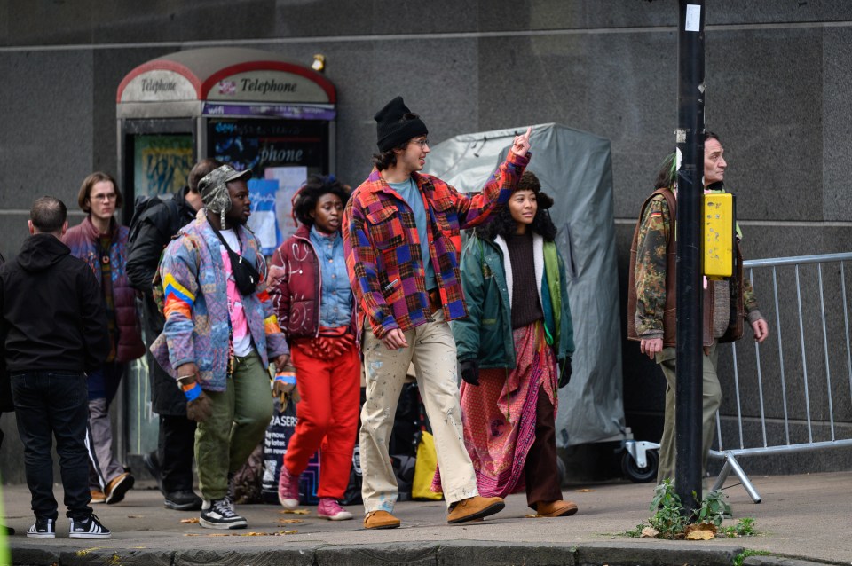 Extras wearing vibrant clothing and bright trousers were spotted in the city