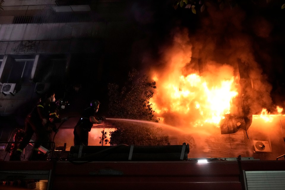 Firefighters and rescuers gather outside a computer shop hit in an Israeli airstrike in central Beirut on Sunday