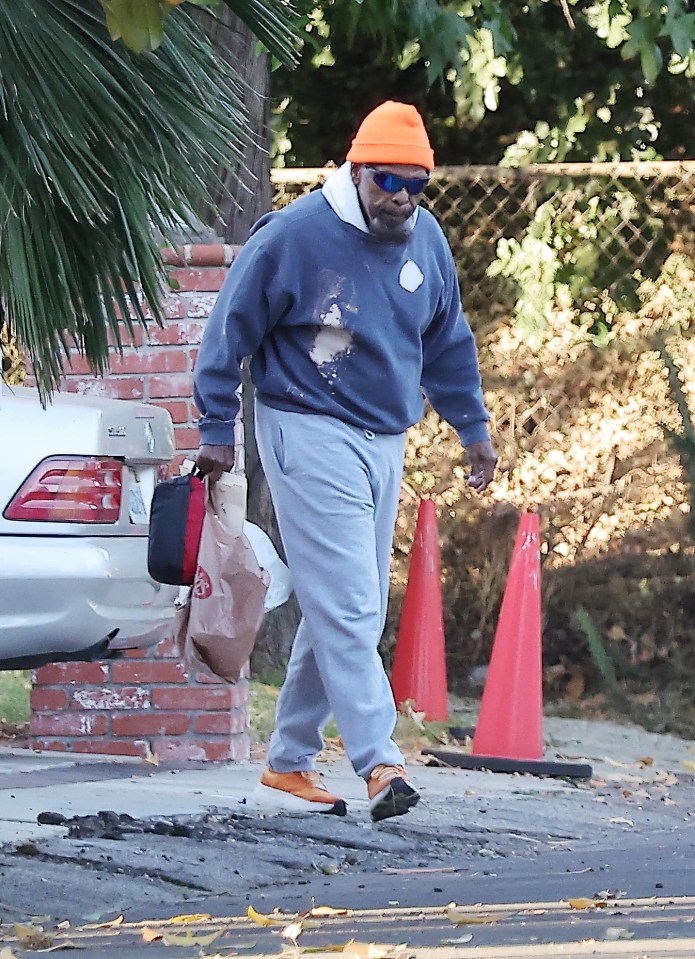 The iconic actor wore a paint-stained blue hoodie and his familiar orange beanie