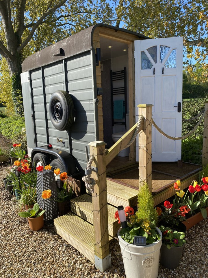 The bathroom is in a horse box, shaded by whispering birch trees