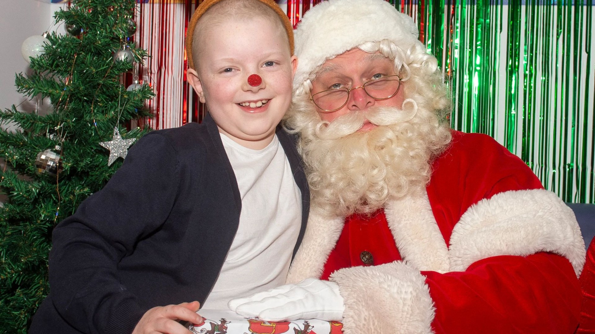 Heartwarming moment Santa visits girl, 8, to give her gift wrapped in paper she designed to help other sick kids