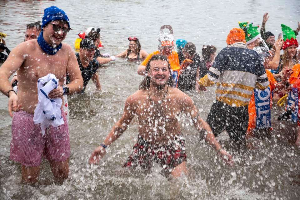 A man in his tartan kilt splashes around in the sea. Credit: Tom Farmer