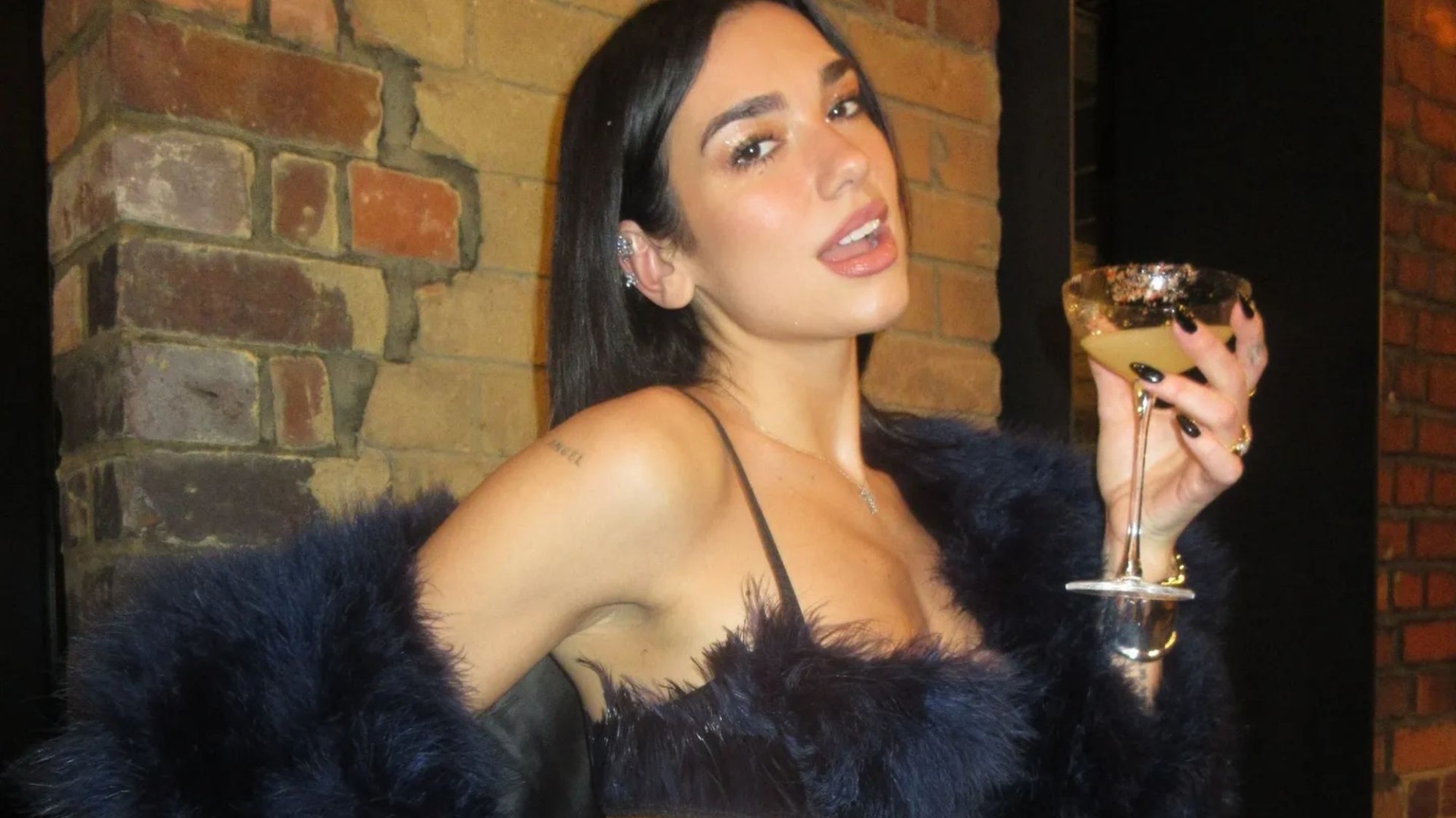 Dua Lipa flashes huge diamond engagement ring as she parties on NYE in barely-there feather bra