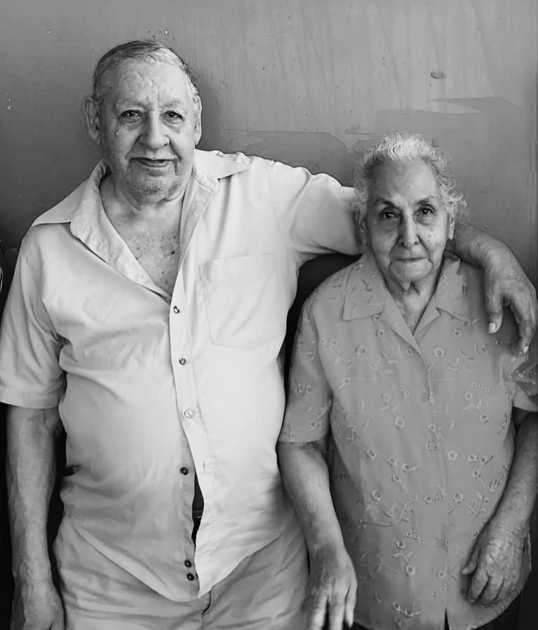 Black and white photo of an elderly couple smiling.