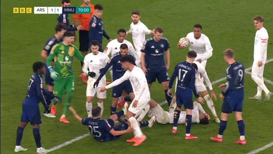 Soccer players in a scrum on the field.