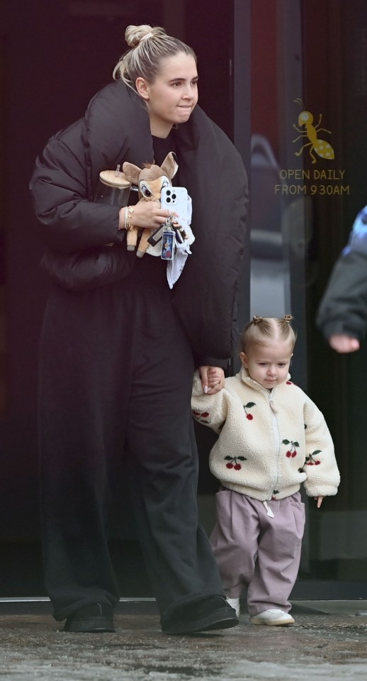 A mother and her baby daughter walking hand-in-hand.