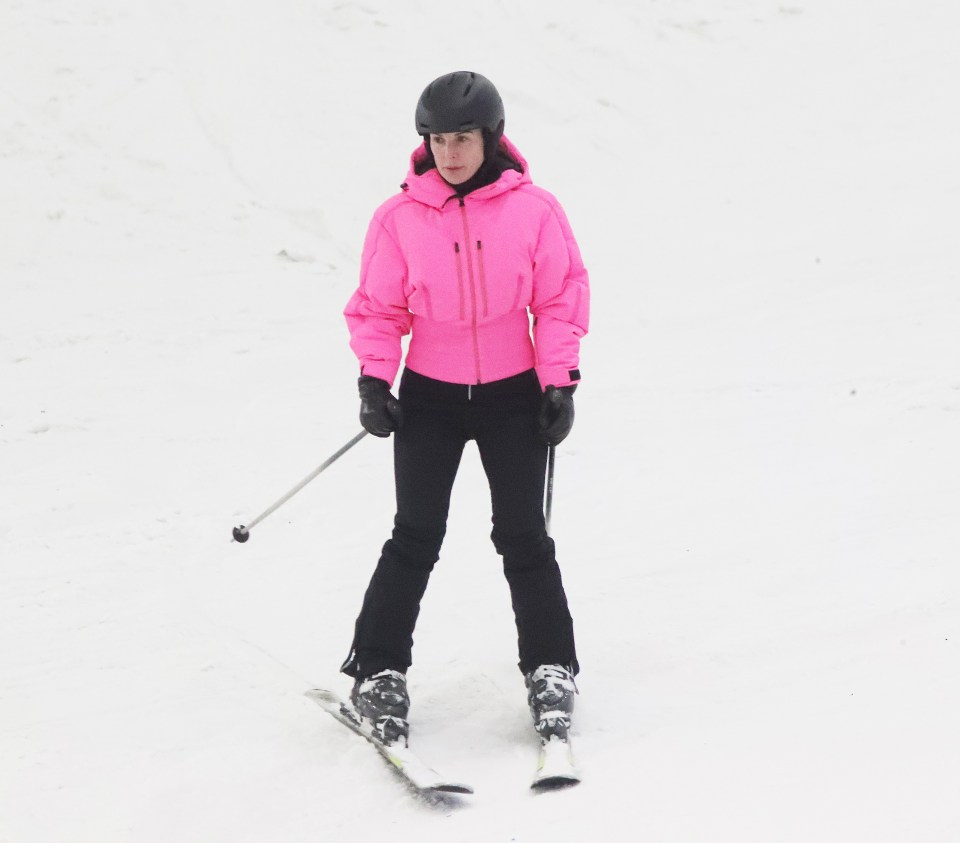 Woman in pink ski jacket skiing.