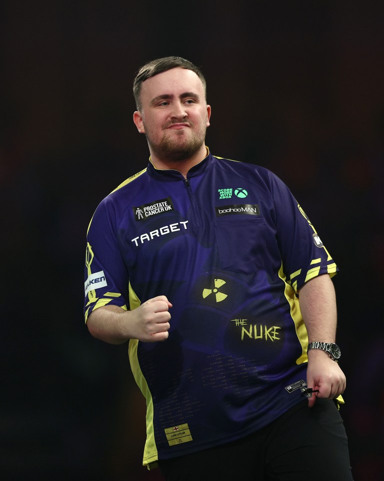 Luke Littler of England celebrates during a darts match.